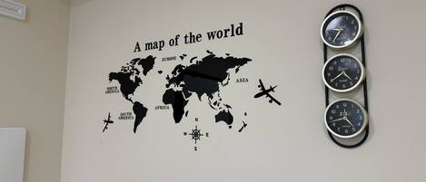 A wall with a world map and a clock displaying times from different cities.