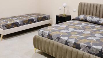 A bedroom with two beds, a nightstand, and a lamp.