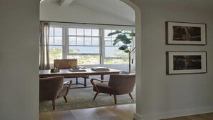 A room with a desk, two chairs, a large window, and two framed pictures on the wall. - Sunset Manor - Designer Gated Estate Above Sunset Strip | Panoramic LA Views (Los Angeles)