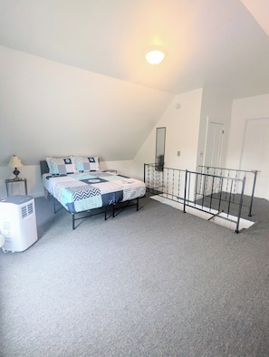 A bedroom with a bed, a heater, a mirror, and a staircase. - newly updated, pet friendly, located in a quiet neighborhood, 10 minute walk to the beach (old orchard beach)