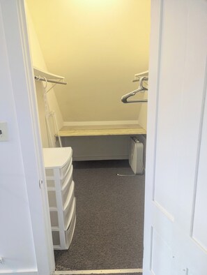 A walk-in closet with a bench, storage drawers, and a radiator. - newly updated, pet friendly, located in a quiet neighborhood, 10 minute walk to the beach (old orchard beach)