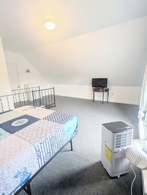 Een kamer met een bed, een verwarming, een televisie en een deur met de tekst 'EXIT'.
