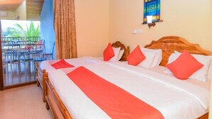 Una habitación de hotel con una cama, un balcón con sillas y un ventanal con vidrieras.