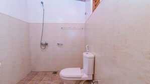 Un baño pequeño con inodoro, ducha y suelo de baldosas.