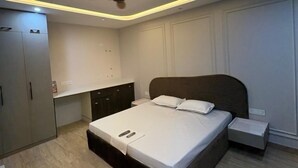 Quarto com cama, mesa de cabeceira, ventoinha no teto e guarda-roupa embutido.