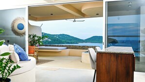 Un interno moderno con un divano curvo, un tavolo in legno e vista sul mare.