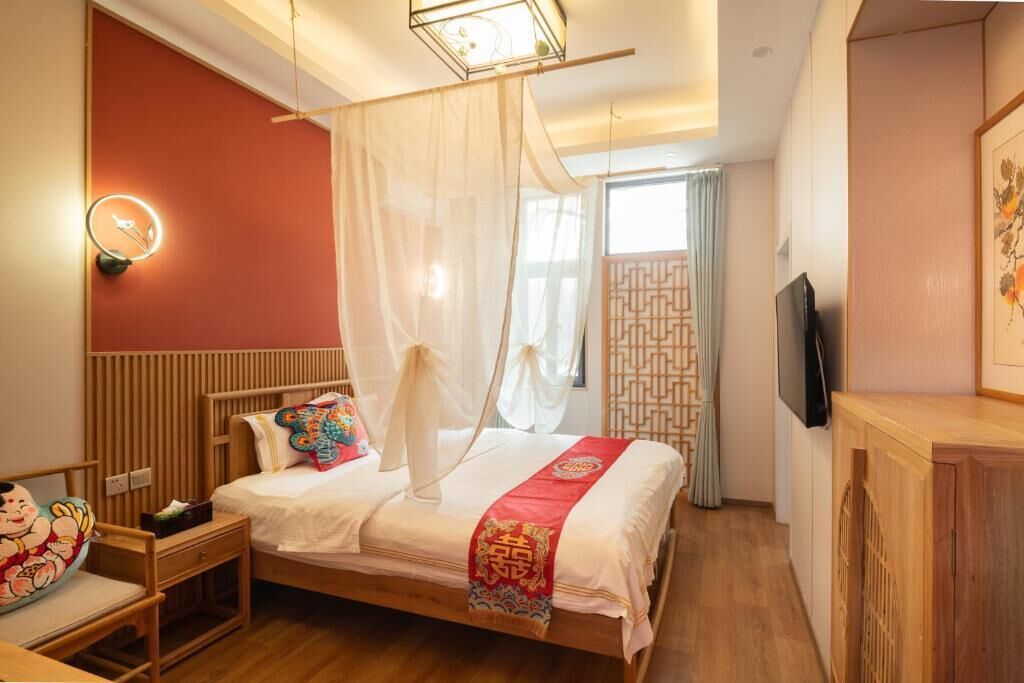 A room with a bed, bedside table, and a TV.