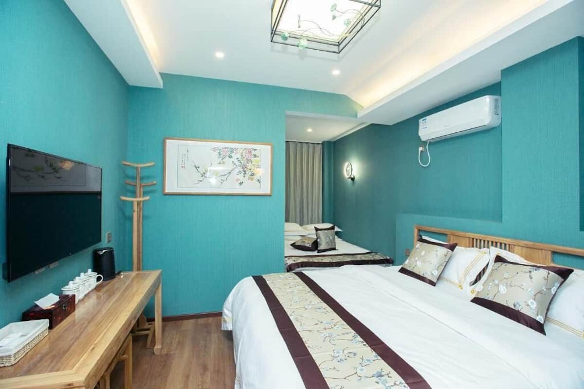Una habitación de hotel con una cama, un escritorio, un televisor y aire acondicionado.