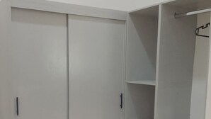 Ein begehbarer Kleiderschrank mit Schiebetür, mehreren Regalen und Schubladen.