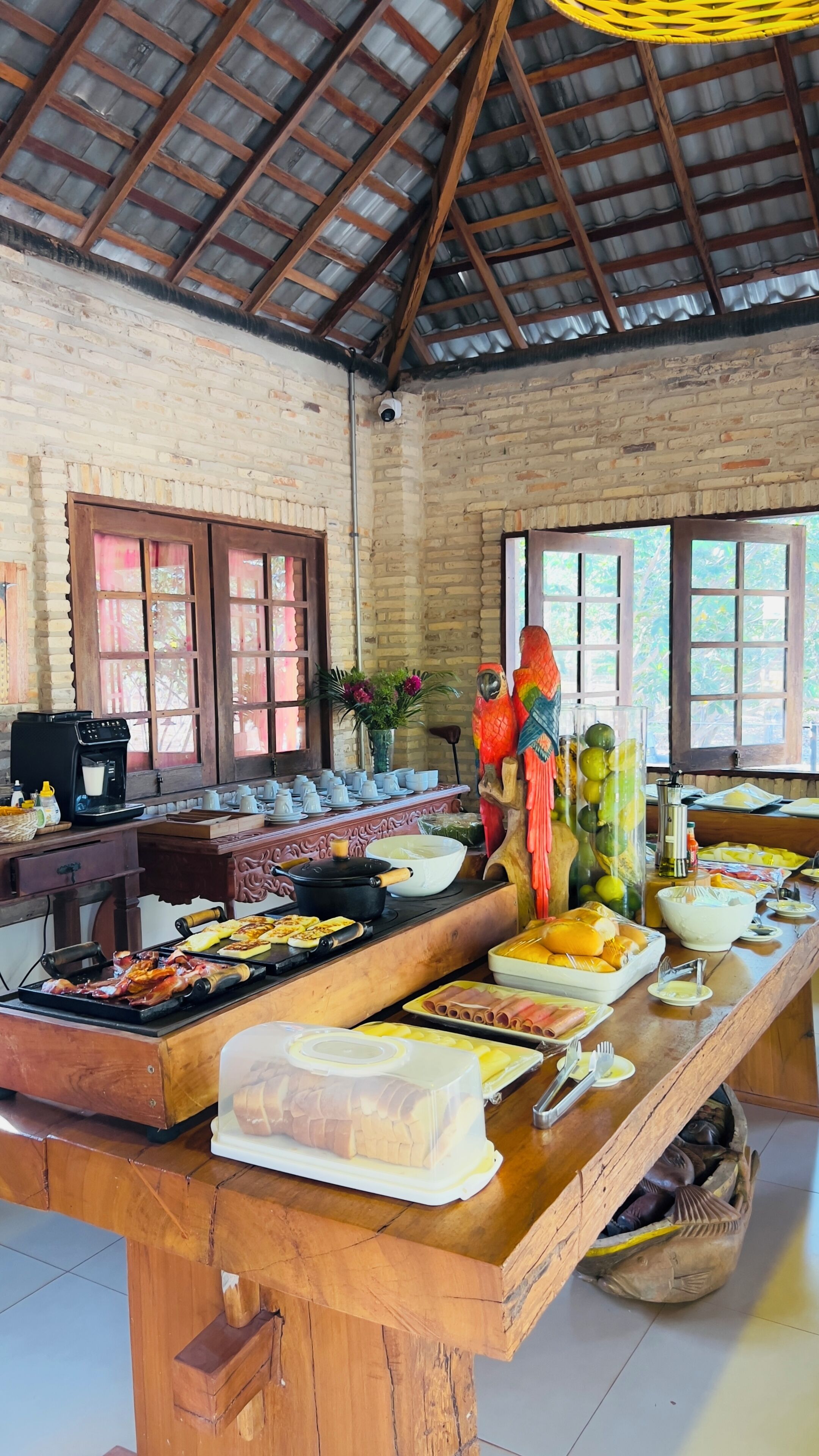 A buffet setup with various food items, a coffee machine, and decorative elements like a parrot sculpture.
