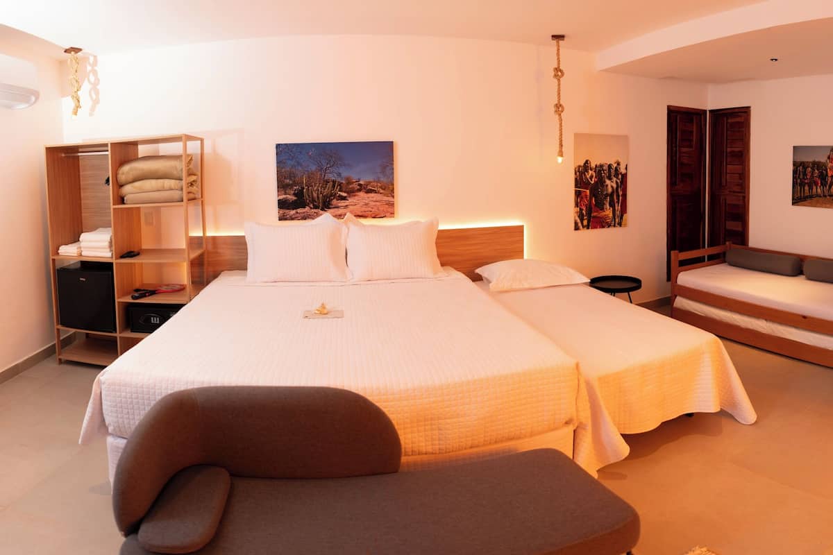 A bedroom with a large bed, a sofa, a desk, and a wardrobe.