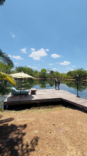 A wooden dock extending into a calm lake, surrounded by greenery and a clear sky. - Nazareth Eco Hotel (José de Freitas)