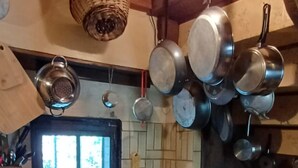 A kitchen with hanging pots, a window, and a tiled backsplash. - The Berger-By Farm and its two outbuildings, in the heart of the Two Lakes region (Pressins)