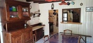 Una cocina con armarios de madera, encimera de madera, una mesa de comedor y un farol colgante.
