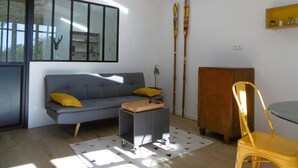 A modern living room with a grey sofa, yellow cushions, a small table, a yellow chair, a wooden cabinet, and a skylight. - Charming holiday cottage with pool-pétanque-table tennis-foosball-BBQ-parking (Roujan)
