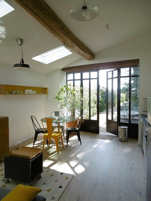 A dining area with a table, chairs, and a potted plant. - Charming holiday cottage with pool-pétanque-table tennis-foosball-BBQ-parking (Roujan)