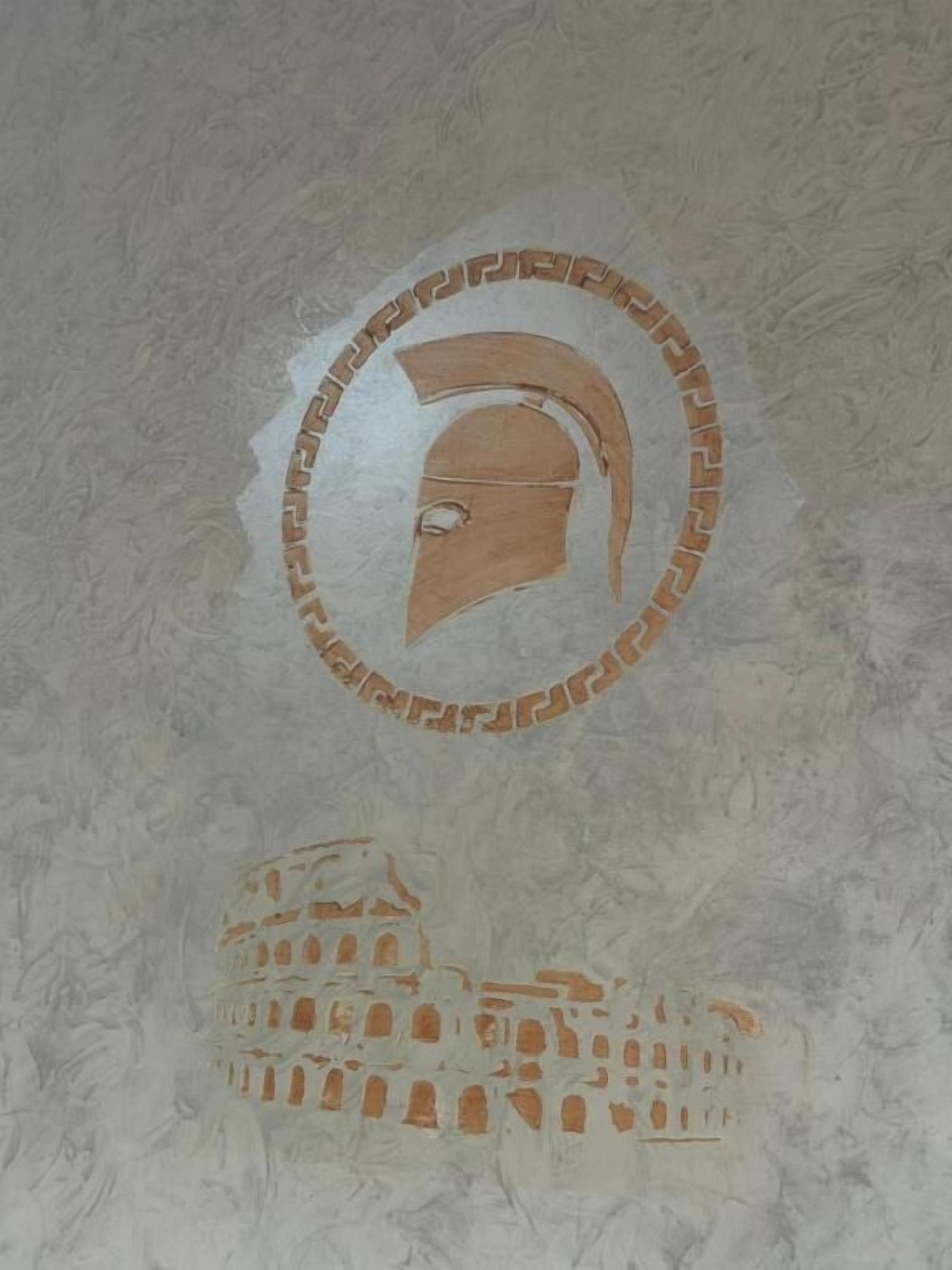 A circular emblem with a helmet and a coliseum on a textured wall.