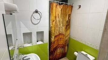 A bathroom with a toilet, sink, and shower curtain.