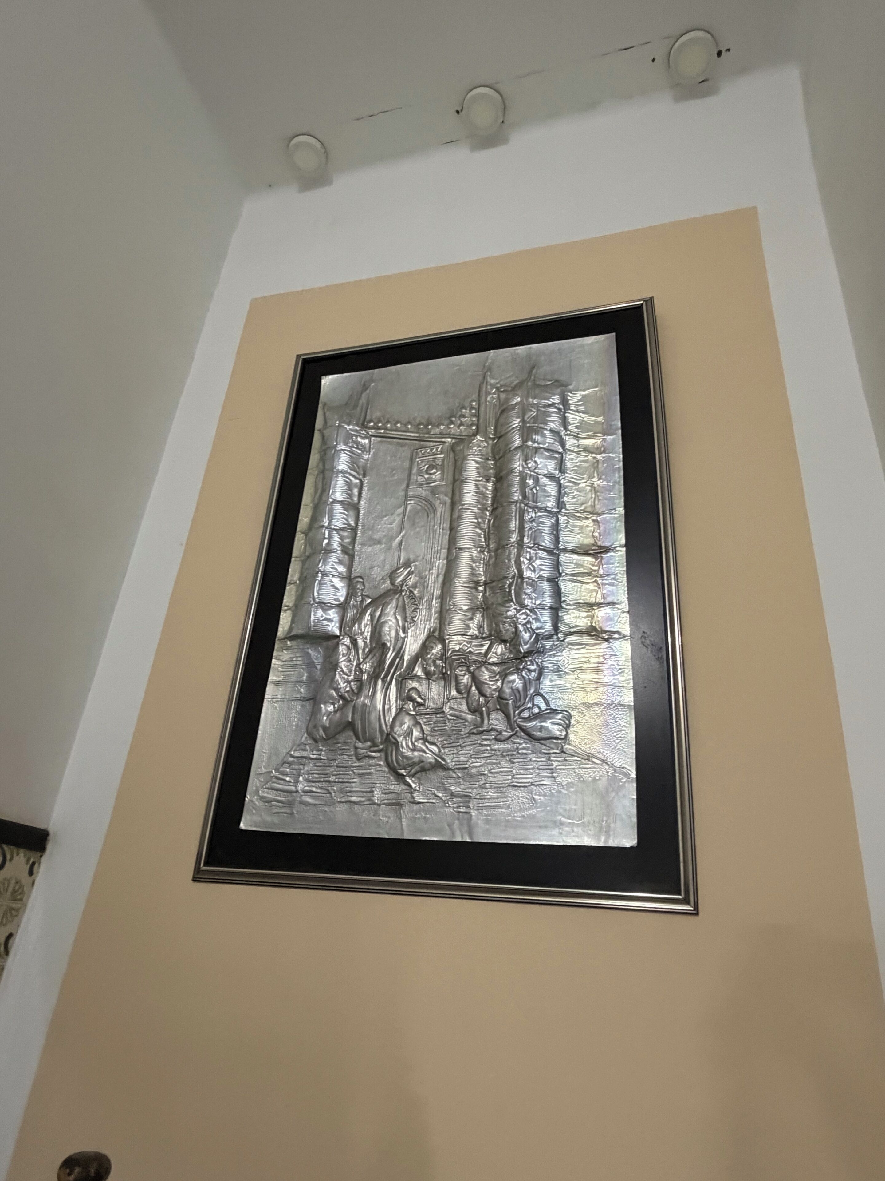 Une œuvre d’art métallique encadrée, accrochée à un mur.