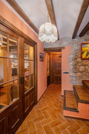 A hallway with a wooden door, a staircase, and a stone wall. - A whole house in the mountains. Perfect for hiking and nature lovers (Farena)