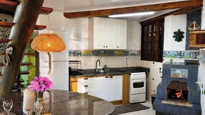 Uma cozinha com armários brancos, fogão e painel de azulejos.