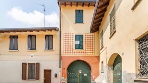 Una calle estrecha con edificios de arquitectura tradicional, incluyendo uno con fachada decorada y una entrada arqueada verde.
