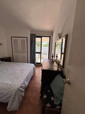 A bedroom with a bed, a dresser, a mirror, and a door leading to a balcony. - Private Pool • 8-Min Walk to Praia da Oura Beach • Prime Albufeira Location (Albufeira)