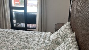 A bedroom with a bed, a window with curtains, and a view of the outside. - Private Pool • 8-Min Walk to Praia da Oura Beach • Prime Albufeira Location (Albufeira)