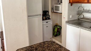 A compact kitchen with white cabinets, a granite countertop, a microwave, and a coffee maker. - Private Pool • 8-Min Walk to Praia da Oura Beach • Prime Albufeira Location (Albufeira)