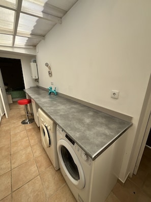 A compact kitchen with a washing machine, a sink, and a countertop. - Private Pool • 8-Min Walk to Praia da Oura Beach • Prime Albufeira Location (Albufeira)