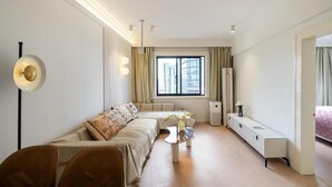 A modern living room with a sofa, a coffee table, and a TV stand. - Yidu Home City View Jing'an Temple (Shanghai)