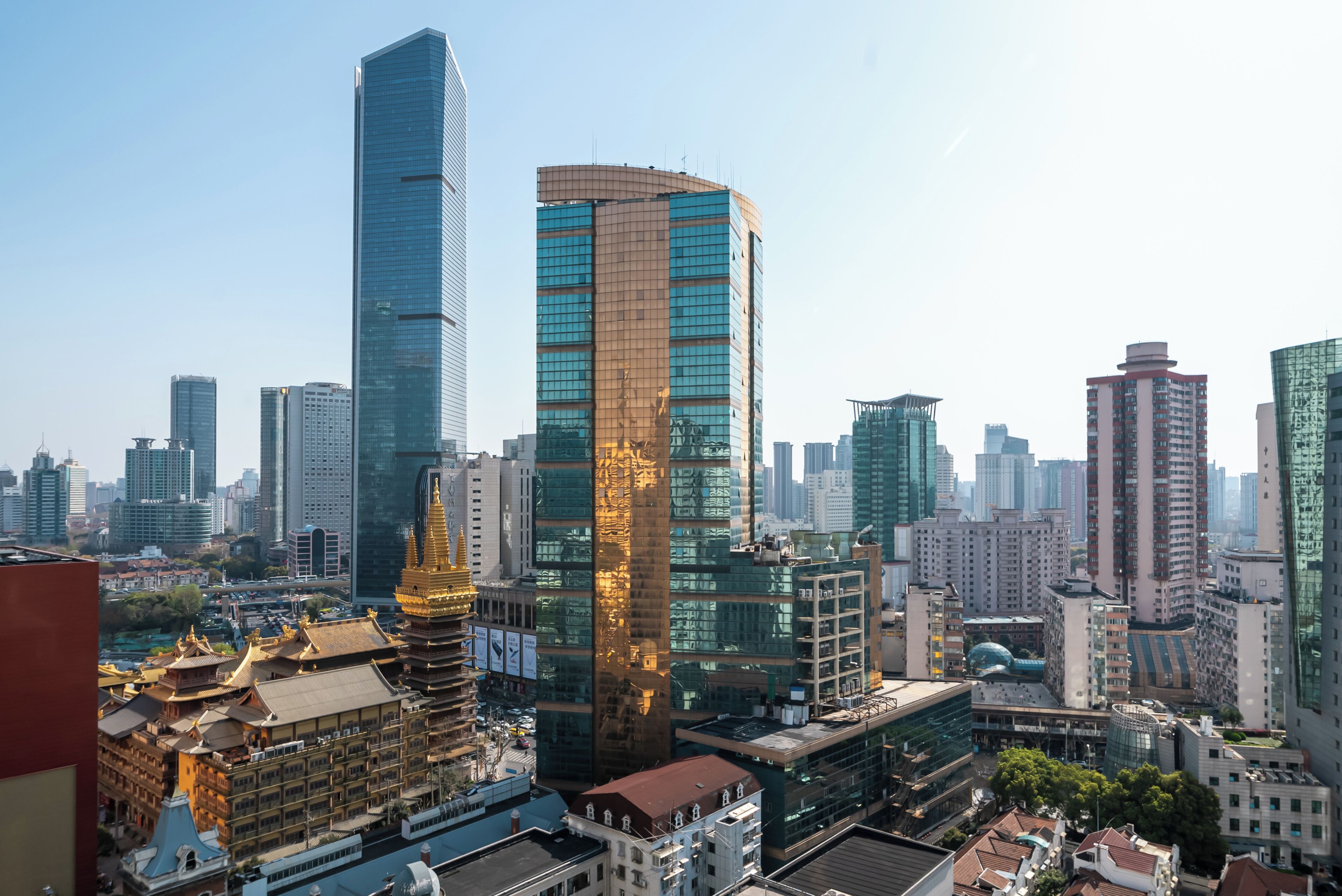 A cityscape with modern high-rise buildings, traditional architecture, and a mix of commercial and residential structures.