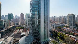 A high-rise building with a curved facade, surrounded by other tall buildings in a cityscape. - Yidu Home City View Jing'an Temple (Shanghai)