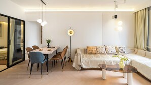 A modern living room with a dining area, a sofa set, and a coffee table. - Yidu Home City View Jing'an Temple (Shanghai)