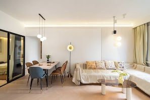 Un salon moderne comprenant un coin repas, un ensemble de canapés et une table basse.