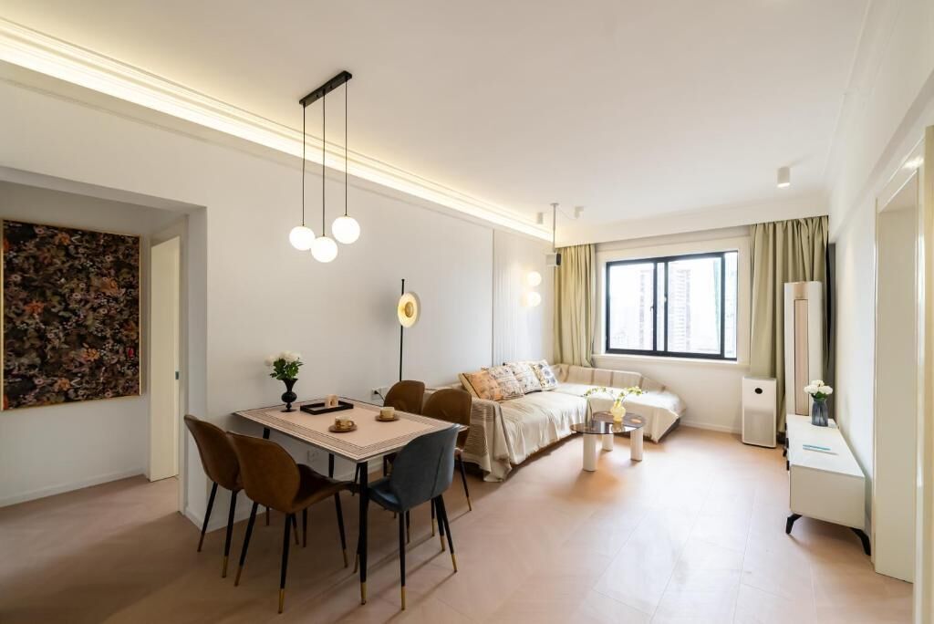 A modern living room with a dining area, a sofa set, a coffee table, and a large window with curtains.
