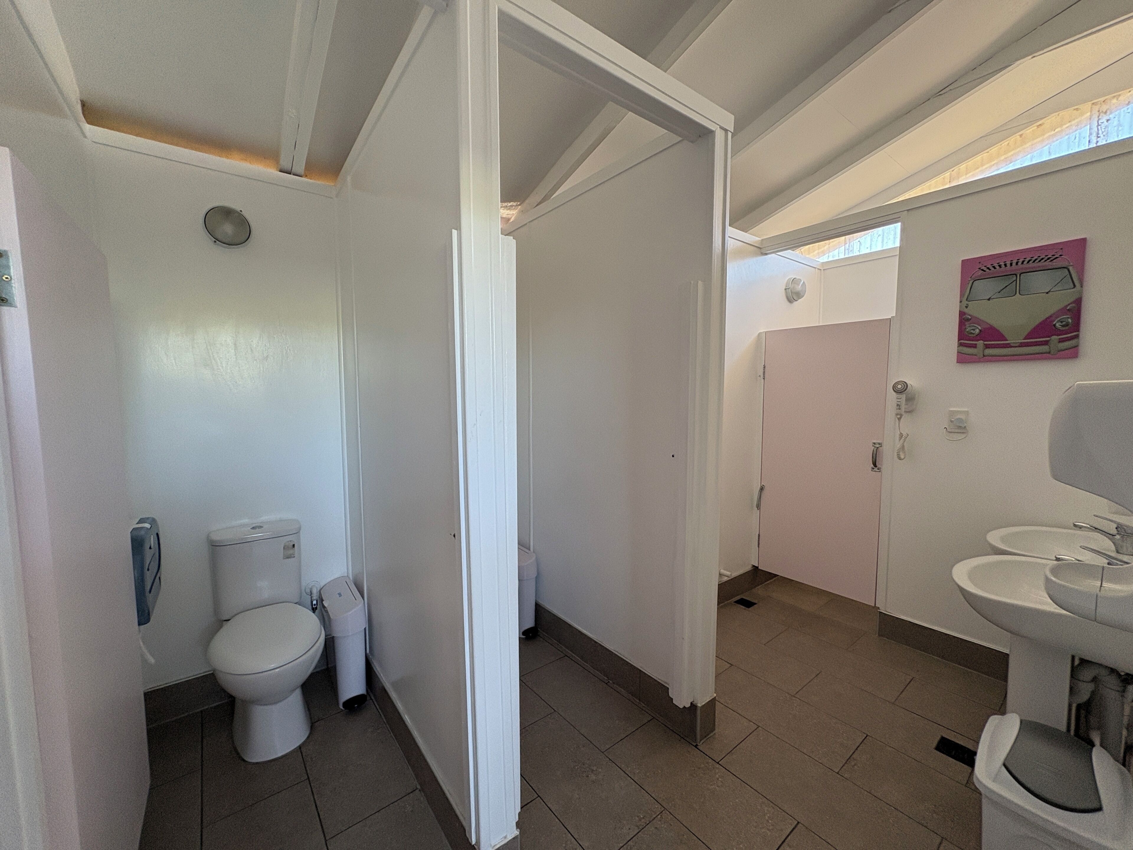 Une salle de bain équipée de toilettes, d’un bidet et d’un lavabo.