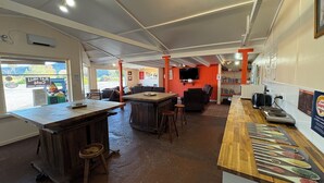 L’intérieur d’un restaurant, avec un bar, des tables et un téléviseur.