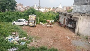A residential area with a white car, a rickshaw, and a woman sitting on a bench. - Amrit Niwas (Ayodhya)