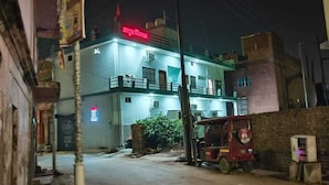 A two-story building with a balcony, a signboard, and a parked vehicle. - Amrit Niwas (Ayodhya)