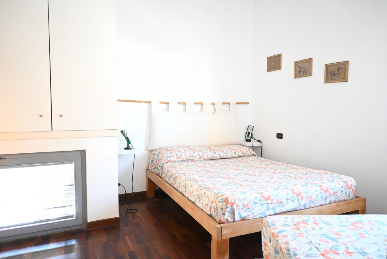 Un dormitorio con cama, escritorio y ventana.