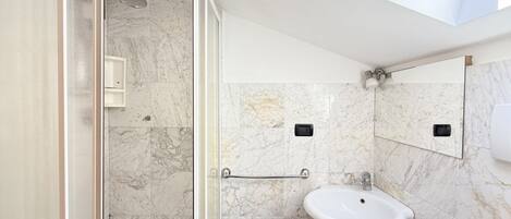 A modern bathroom with a shower, a sink, and a mirror.