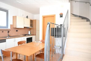 A kitchen with a dining table, chairs, and a staircase. - SE288 – Senigallia, one-bedroom apartment with air conditioning 50 metres from the sea (Senigallia)