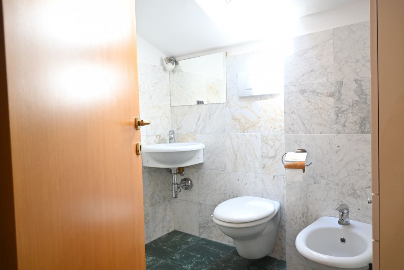 A bathroom with a toilet, sink, and bidet.