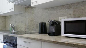 A kitchen with a microwave, coffee maker, and stove. - Beautiful apartment for 5 guests with WIFI, TV and patio (Lodrino)