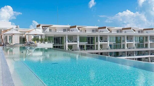A modern hotel with a long swimming pool, multiple balconies, and a clear blue sky. - Salt Air in Cancun (Cancún)