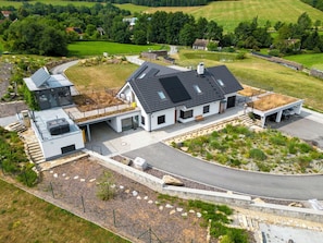 A modern house with a large garage, a covered outdoor area, and a well-maintained garden.