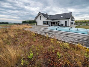 A modern house with a flat roof, large windows, and a covered outdoor area. - Beautiful apartment for 2 people with pool, WIFI, hot tub, A/C, TV, patio and pets allowed (Dačice)