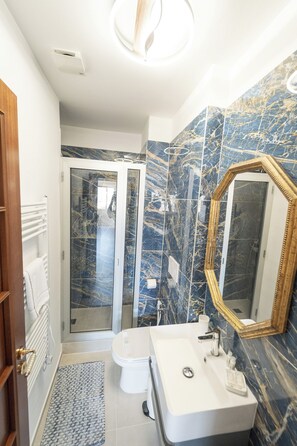 Ein Badezimmer mit Waschbecken, Spiegel und Dusche.