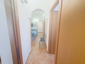 A narrow hallway with a dining area at the end, featuring a table and chairs. - Wonderful private villa for 8 people with WIFI, A/C, TV, terrace and pets allowed (Villasimius)